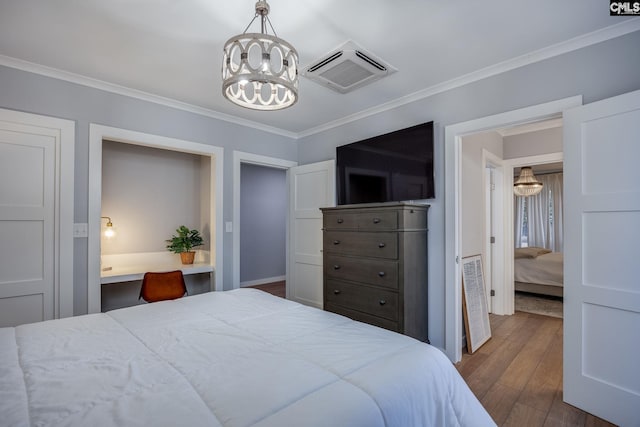 bedroom with crown molding, built in desk, dark wood-type flooring, and a chandelier