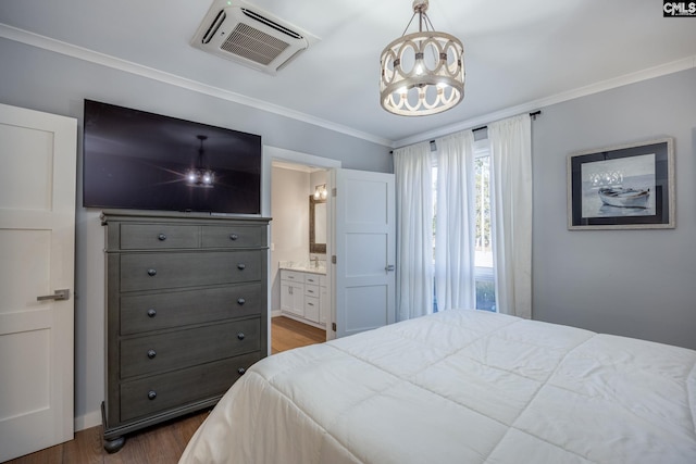 bedroom featuring ensuite bath, crown molding, dark wood-type flooring, and a notable chandelier