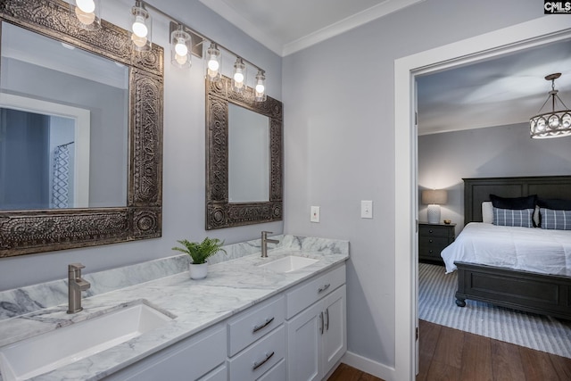 bathroom with crown molding, hardwood / wood-style floors, and vanity