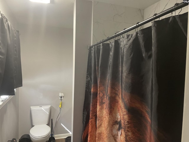 bathroom featuring a shower with curtain and toilet