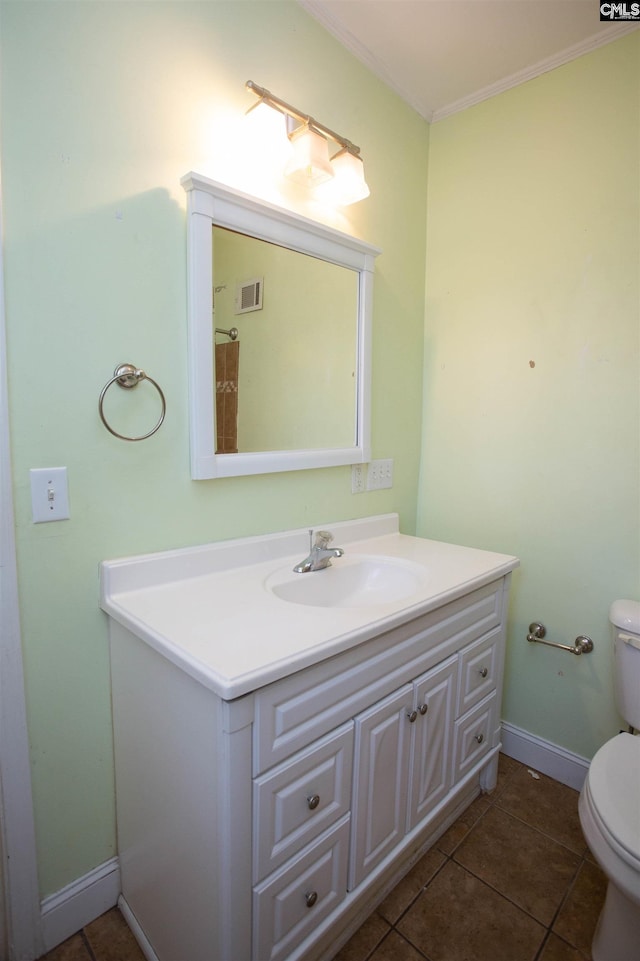 bathroom with tile patterned floors, crown molding, vanity, and toilet