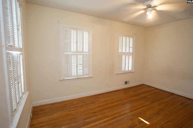 empty room with ceiling fan and hardwood / wood-style flooring