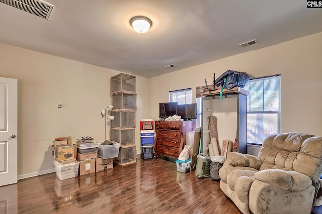 living area with plenty of natural light and dark hardwood / wood-style floors