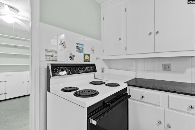 kitchen featuring white range with electric stovetop, white cabinetry, tasteful backsplash, and light colored carpet