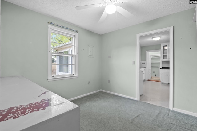 interior space featuring ceiling fan, carpet, and a textured ceiling