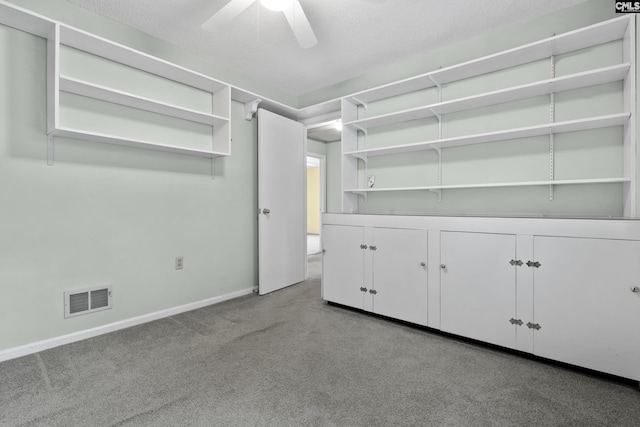 spare room with light carpet, ceiling fan, and a textured ceiling