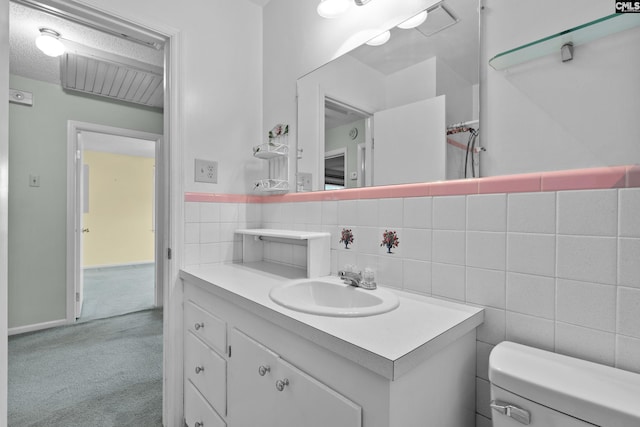 bathroom with decorative backsplash, a textured ceiling, vanity, tile walls, and toilet