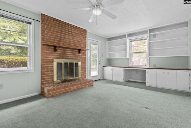 unfurnished living room with light carpet, a textured ceiling, ceiling fan, built in features, and a fireplace