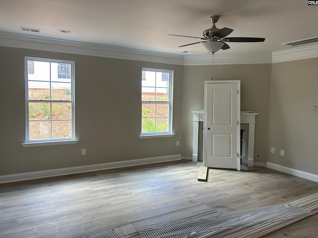 spare room featuring a fireplace, ceiling fan, and ornamental molding