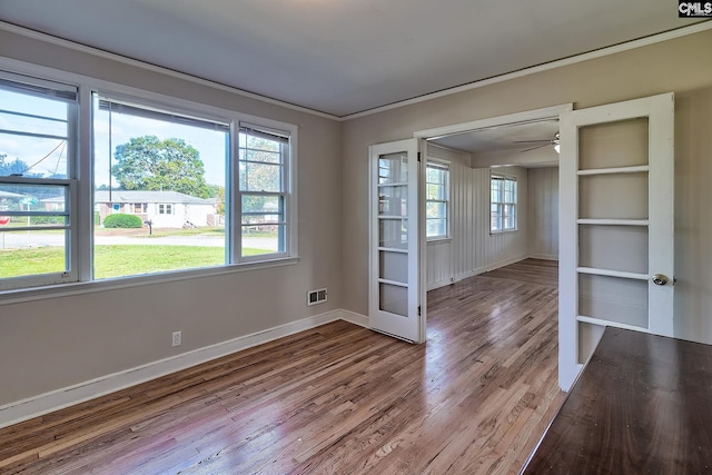 empty room featuring ceiling fan, crown molding, and light wood-type flooring