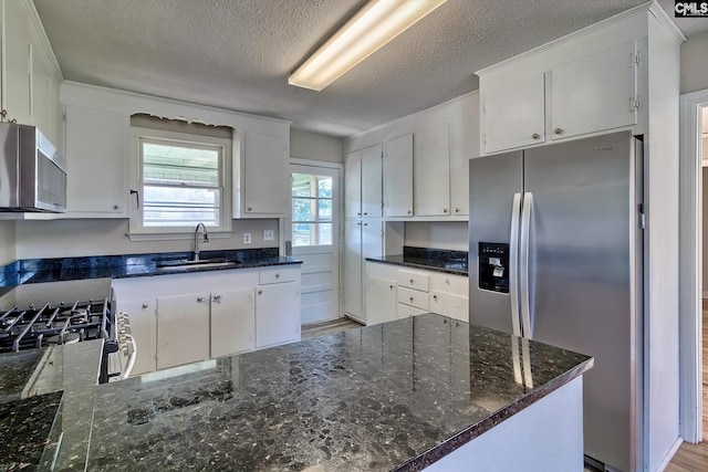 kitchen with stainless steel appliances, white cabinetry, and sink