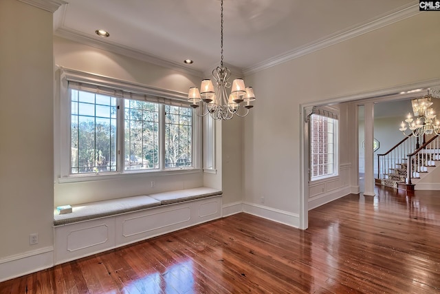 unfurnished dining area featuring crown molding, dark wood-type flooring, and an inviting chandelier