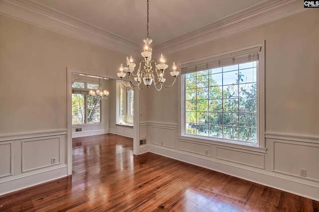 unfurnished dining area with hardwood / wood-style flooring, crown molding, plenty of natural light, and a notable chandelier