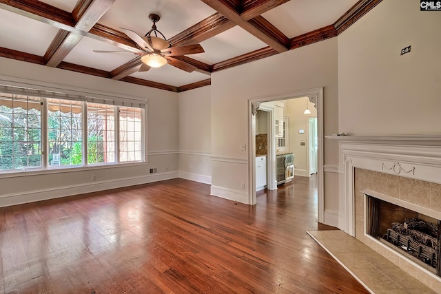 unfurnished living room featuring ceiling fan, coffered ceiling, beamed ceiling, a fireplace, and hardwood / wood-style flooring