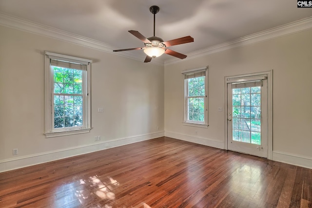 empty room with plenty of natural light, ceiling fan, wood-type flooring, and crown molding