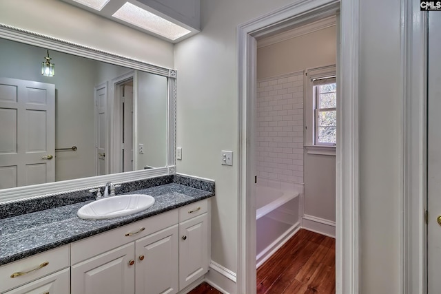 bathroom featuring vanity, wood-type flooring, tiled shower / bath combo, and a skylight