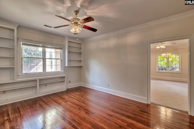 spare room with built in shelves, ceiling fan, crown molding, and hardwood / wood-style floors