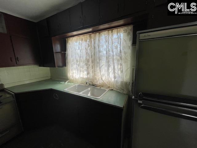 kitchen featuring sink, refrigerator, and plenty of natural light