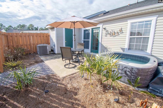 view of patio / terrace featuring a hot tub and central AC unit