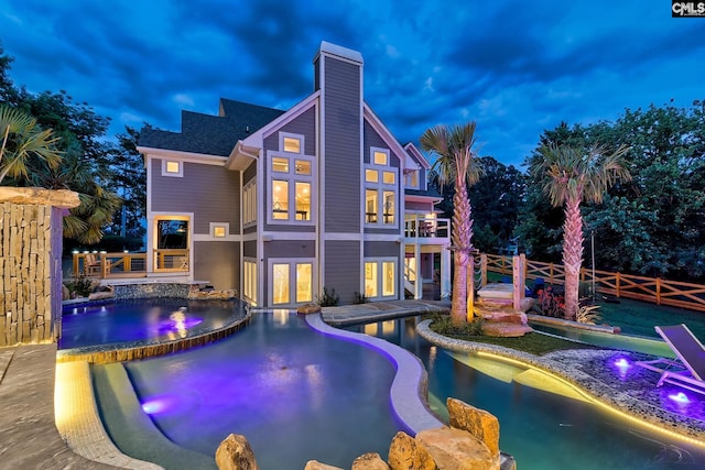 pool featuring fence, french doors, and an in ground hot tub