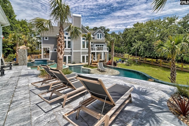 pool with a yard, a patio area, a jacuzzi, and fence