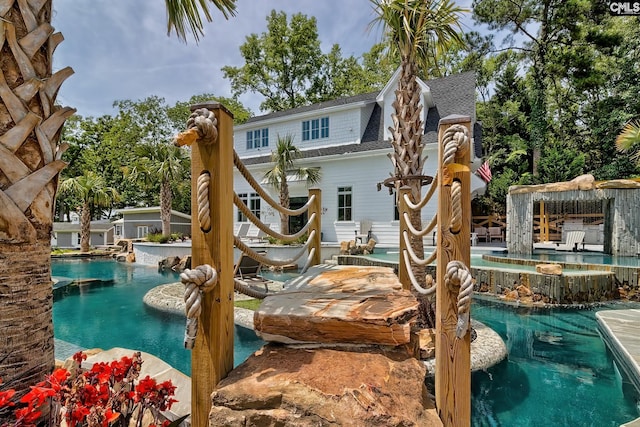 view of playground featuring an outdoor pool and an in ground hot tub