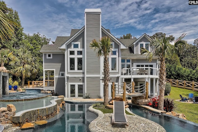 rear view of property with a patio, a balcony, fence, french doors, and roof with shingles