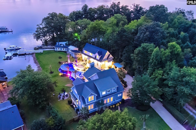 aerial view at dusk featuring a water view