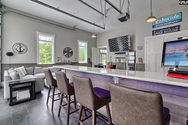 kitchen featuring open floor plan, light countertops, a breakfast bar area, and decorative light fixtures