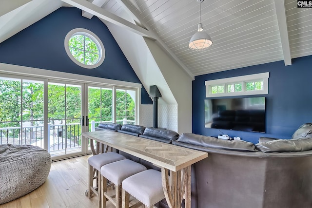 living room featuring plenty of natural light, high vaulted ceiling, light wood-type flooring, and beam ceiling