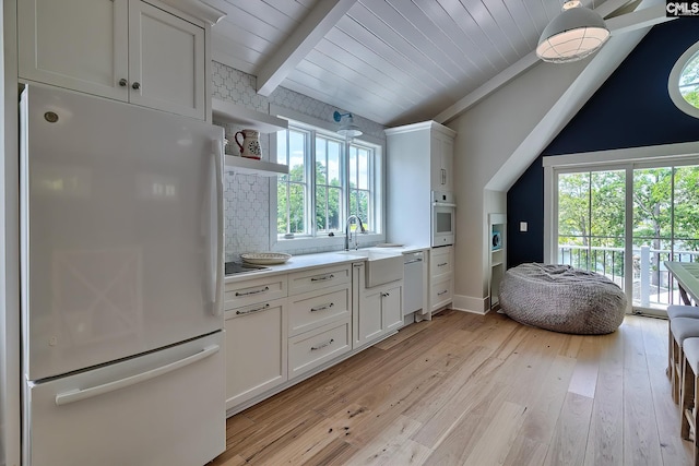 kitchen featuring light wood-style flooring, white appliances, a sink, white cabinetry, and light countertops