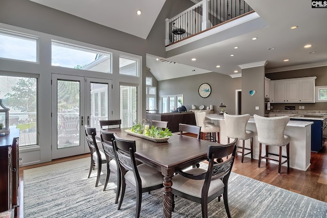 dining area with recessed lighting, a high ceiling, wood finished floors, french doors, and crown molding