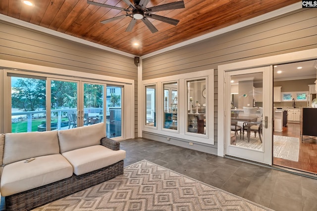 sunroom featuring a ceiling fan, wooden ceiling, and a sink