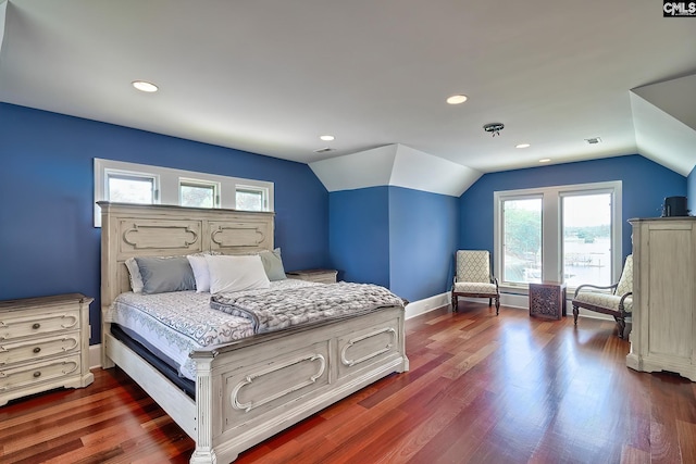 bedroom featuring lofted ceiling, visible vents, dark wood finished floors, and baseboards