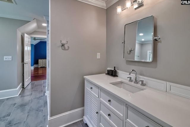 bathroom with crown molding, vanity, and baseboards