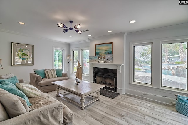 living area featuring recessed lighting, visible vents, ornamental molding, light wood-style floors, and a fireplace with flush hearth