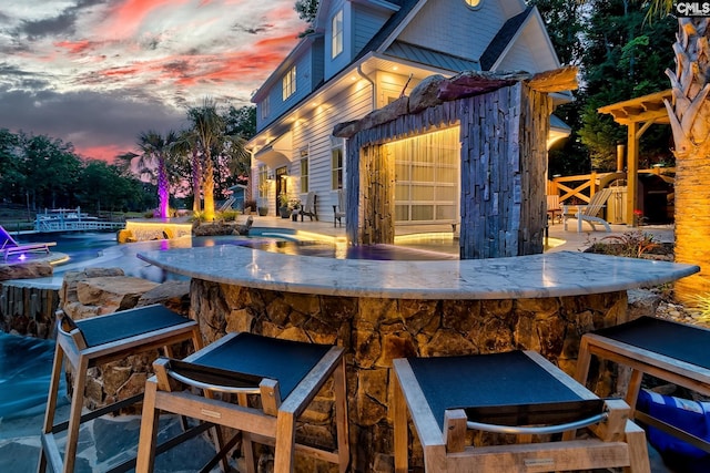 view of patio / terrace featuring exterior bar and a pool