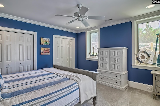 bedroom with light carpet, two closets, visible vents, and crown molding