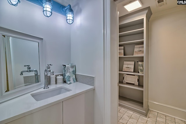 bathroom featuring tasteful backsplash, vanity, and visible vents