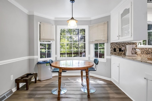 dining room featuring crown molding and dark wood-type flooring