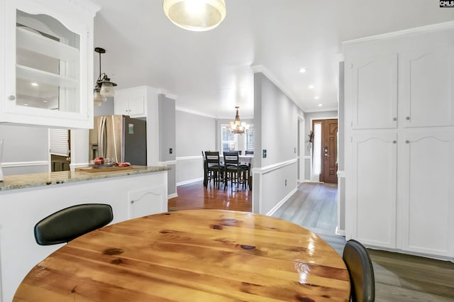 dining area featuring dark hardwood / wood-style floors, ornamental molding, and a chandelier