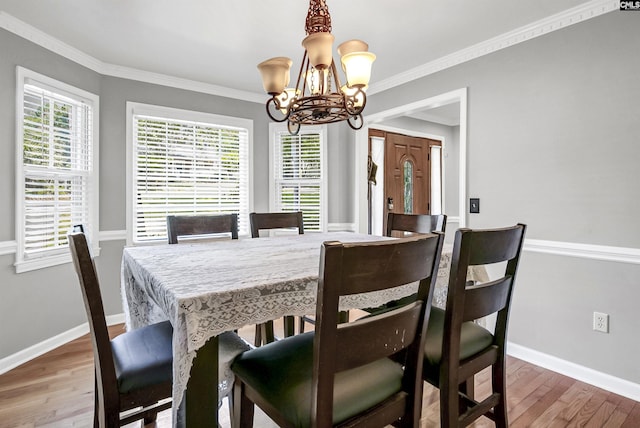 dining area featuring a chandelier, wood-type flooring, and ornamental molding