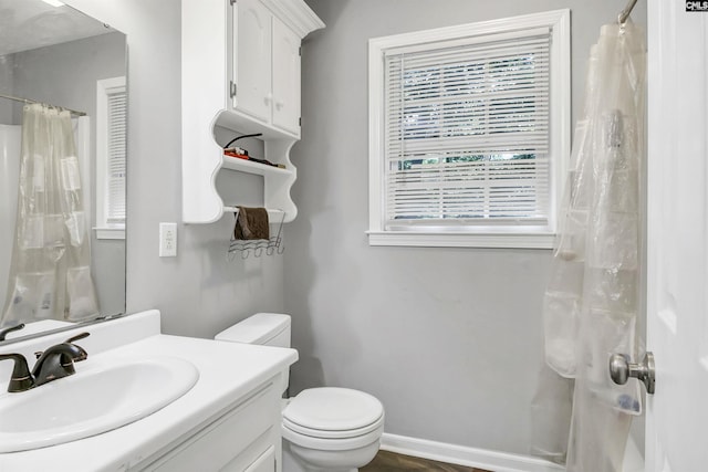 bathroom featuring vanity, toilet, and walk in shower