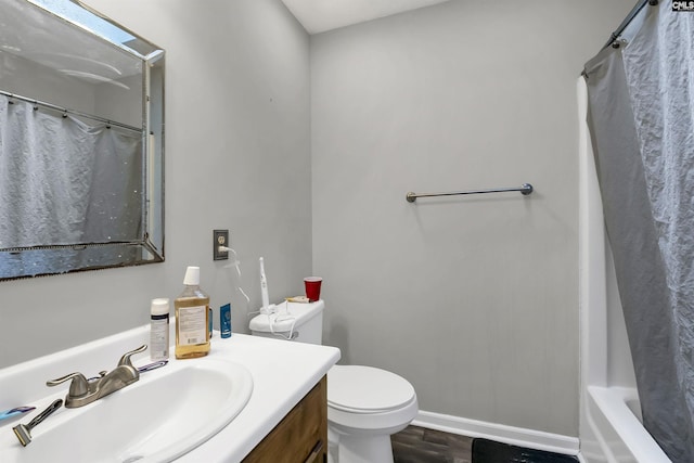 bathroom with wood-type flooring, vanity, and toilet