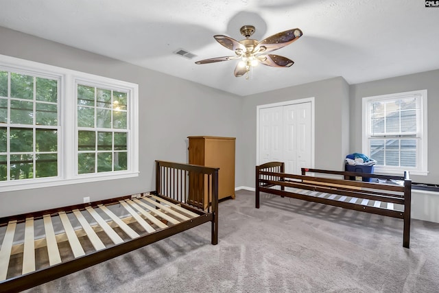 bedroom with carpet, ceiling fan, and a closet