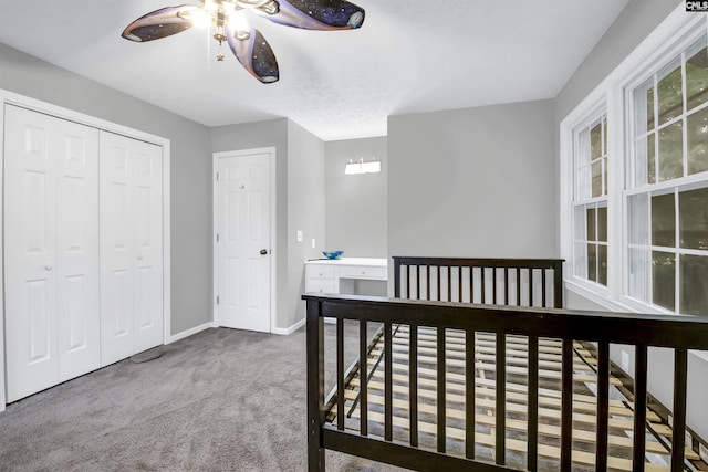 carpeted bedroom featuring ceiling fan and a closet