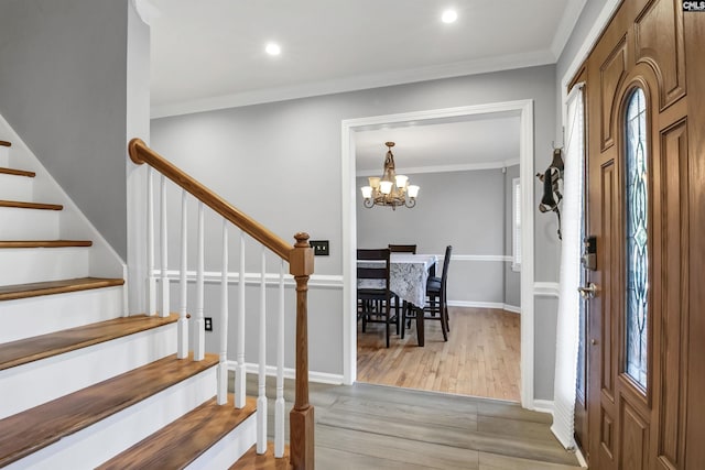 entryway featuring light hardwood / wood-style flooring, an inviting chandelier, and ornamental molding