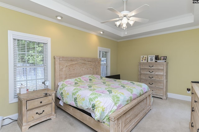 bedroom with ceiling fan, a raised ceiling, ornamental molding, and light carpet