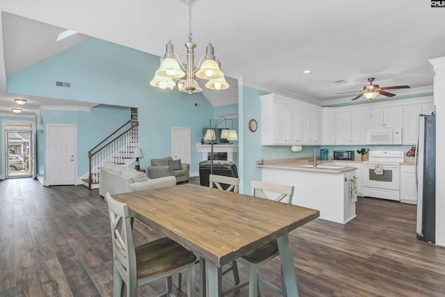 dining room featuring ceiling fan with notable chandelier, sink, crown molding, vaulted ceiling, and dark hardwood / wood-style flooring