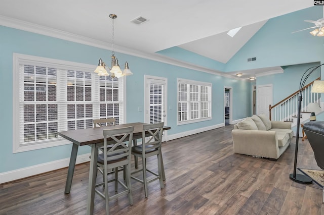 dining room with lofted ceiling, dark hardwood / wood-style flooring, ceiling fan with notable chandelier, and ornamental molding